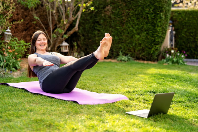 Young-Woman-Practising-Pilates-in-front-of-Laptop