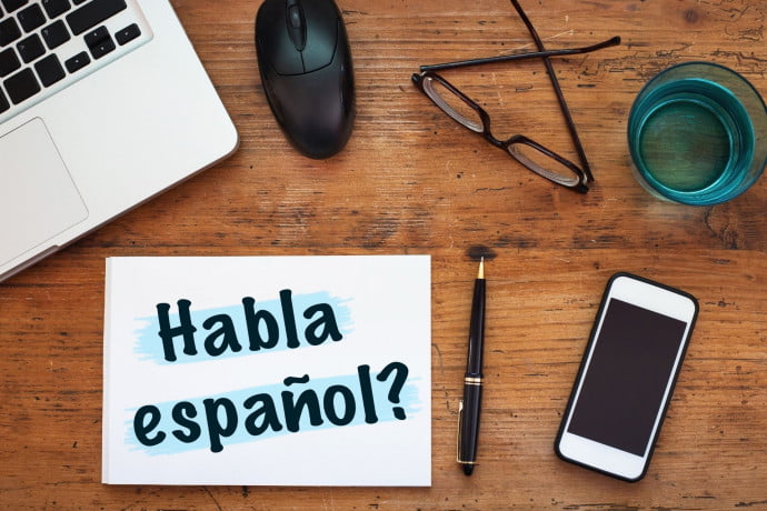 Learn spanish sign on desk with laptop and phone for online lesson
